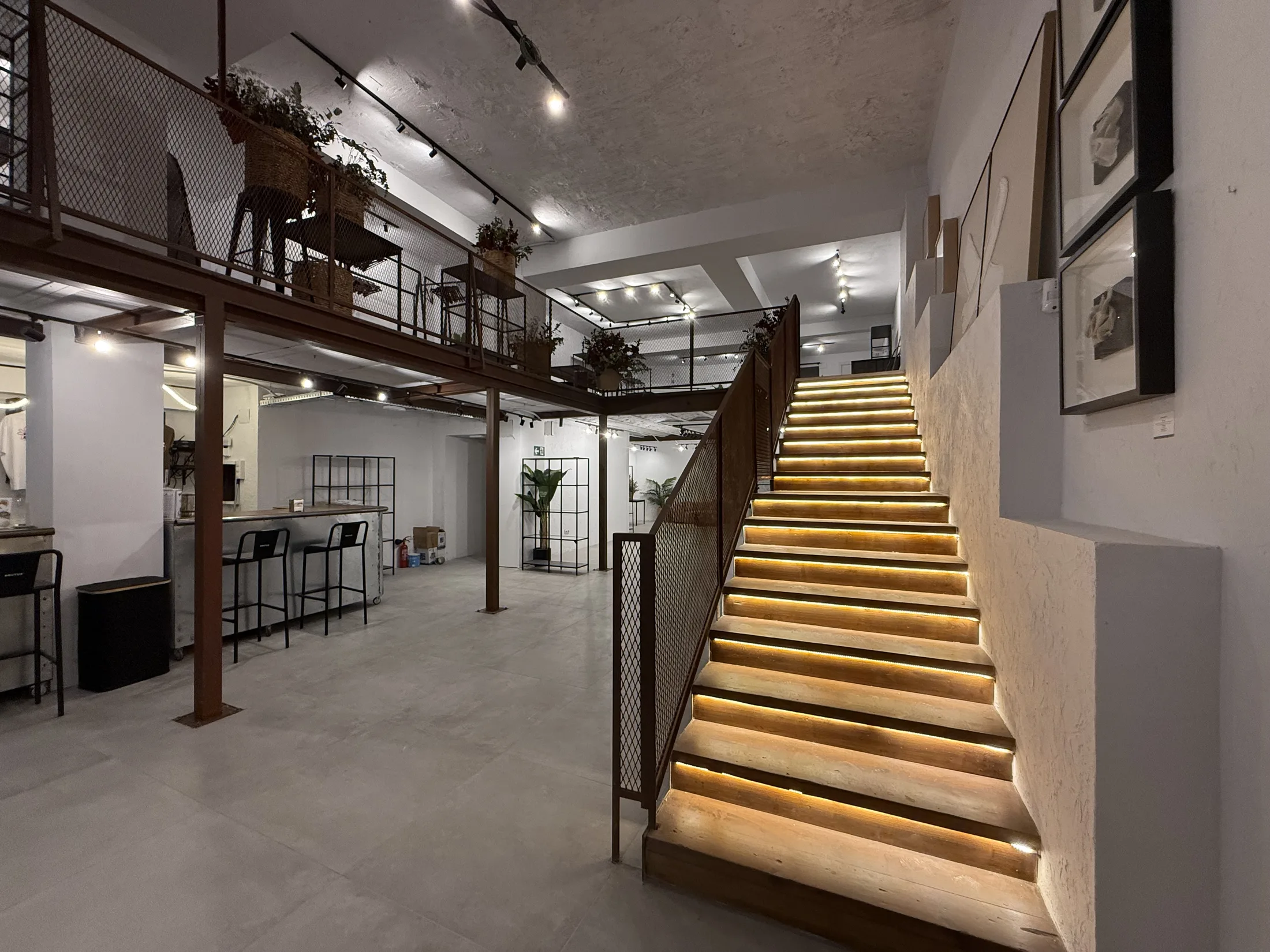 Escalera iluminada hacia la entreplanta de Brutta